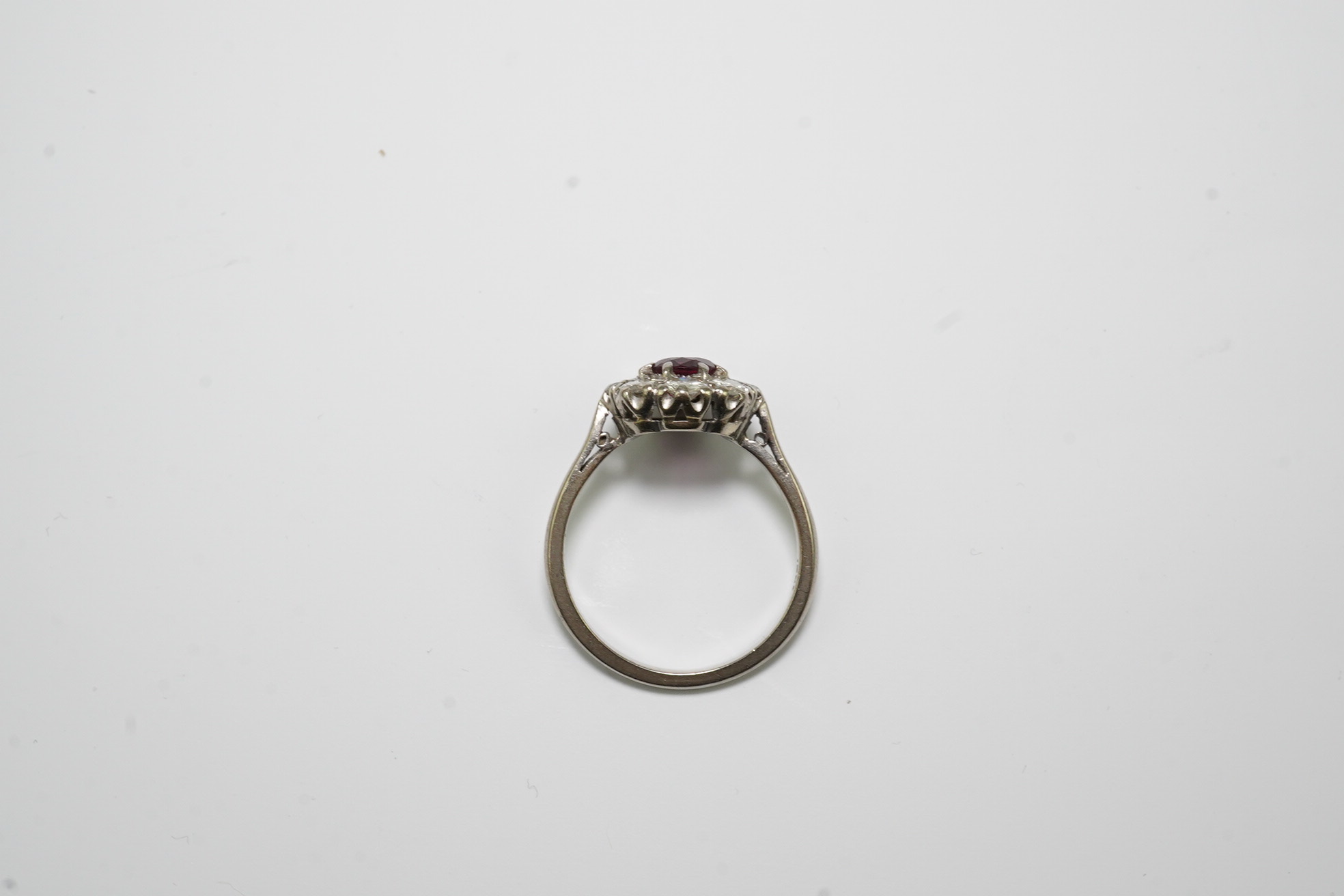 An 18ct white gold, ruby and diamond set oval cluster ring